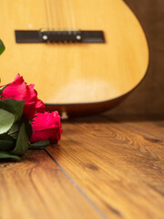 Wooden guitar and red rouses bouquet after a concert. Music performance appreciation concept. Enjoy classic musical instrument.