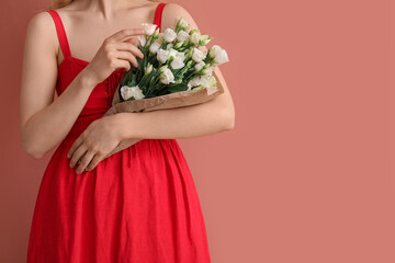 Young woman with bouquet of beautiful eustoma flowers on pink background