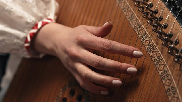 Woman playing on ethnic traditional ukrainian instrument bandura or pandora