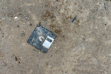 An old floppy disk abandoned on the floor damaged over time.