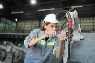 Female industrial engineer working at automated AI robotic production factory.