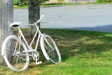 An adult bike painted white as a memorial site for a previous bicycle crash. The ghost bike is a...