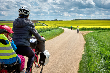 Aventures en famille avec les voyageurs à vélo à travers les champs de colza jaune en France