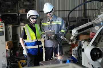 Robotics engineer working on maintenance of robotic arm in factory warehouse. Business technology.