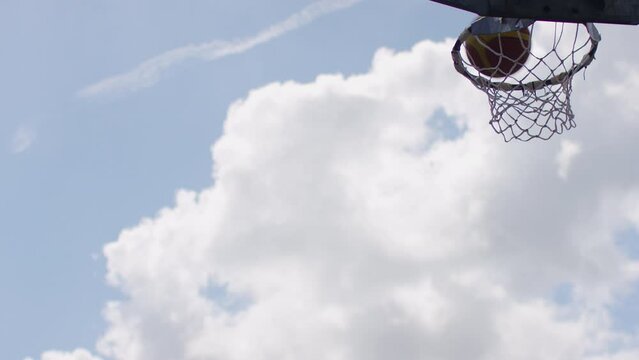 Wide angle view of basketball going through an outdoor net, in slow motion - with space for text
