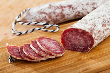 Close-up of spiced spanish longaniza sausages at wooden background