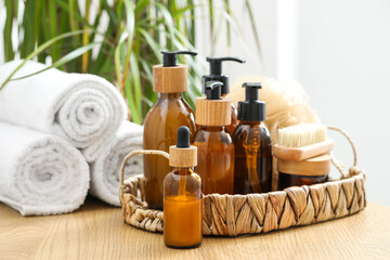Wicker tray with bathing supplies and towels on table