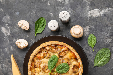 Mushroom pie with spinach leaves and champignons on dark grey grunge background