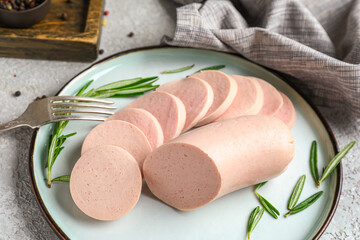 Plate with tasty boiled sausage on light background
