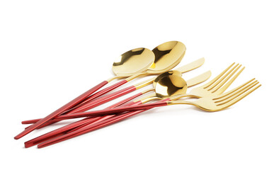 Golden set of cutlery with red handles on white background
