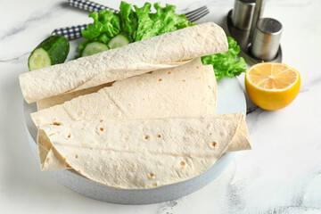 Plate with fresh lavash on white marble background