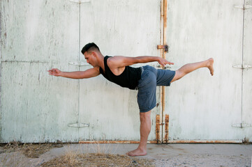 Photograph of a man practicing yoga in a grungy urban environment - 601226421