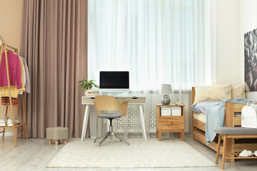 Stylish teenager's room interior with computer and comfortable bed