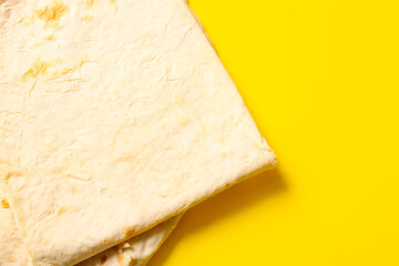 Fresh thin lavash on yellow background