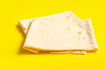 Fresh thin lavash on yellow background