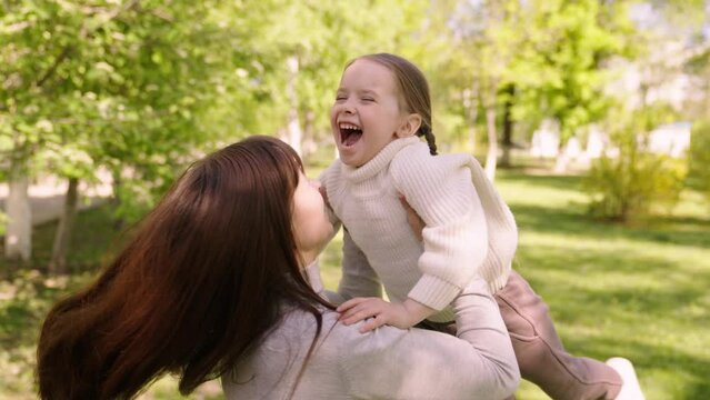 happy family park. mother hugs running cheerful child. portrait kid child girl smile. parent hugging kissing little child. adoptive parent. little daughter girl. cute little girl hugging mom enjoy