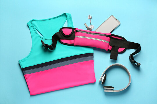 Flat lay composition with stylish pink waist bag on light blue background