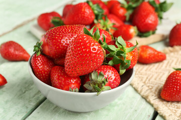 Bowl of fresh strawberries on green wooden background