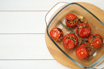 Delicious stuffed tomatoes with minced beef, bulgur and mushrooms on white wooden table, top view. Space for text