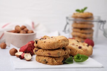 Cookies with freeze dried fruits, nuts and mint on white table, closeup. Space for text