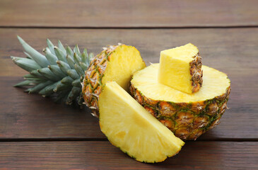 Delicious cut ripe pineapple on wooden table