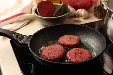 Cooking vegan cutlets in frying pan on stove