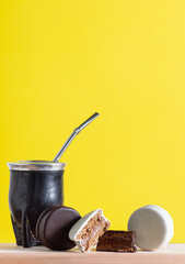 Artisanal alfajores of cornstarch with coconut, white chocolate and dark chocolate with dulce de leche on wooden mat