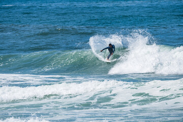 Fototapeta premium Young athletic surfer rides the wave