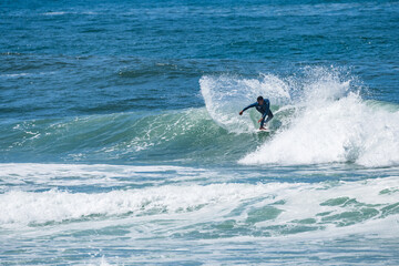 Fototapeta premium Young athletic surfer rides the wave