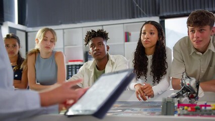 Close up of female teacher with digital tablet teaching high school student STEM class - shot in slow motion - Powered by Adobe