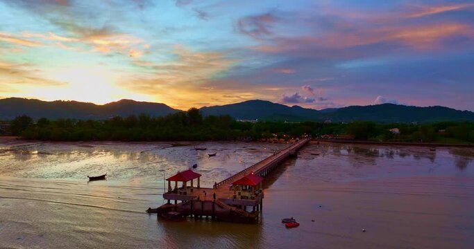 .aerial photography cloud above Palai pier at beautiful sunset..Palai pier is next to Chalong pier..fishing boats parking on the beach..colorful cloud above the mountain range background.