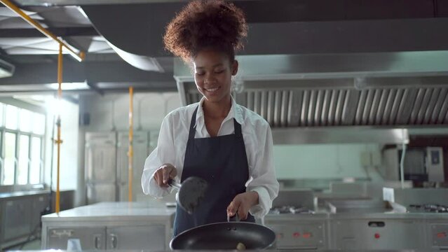 Happy cheerful female chef showing a funny dancing in the kitchen.