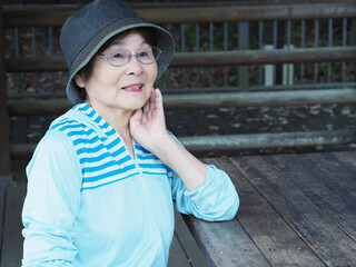 頬杖をついて座る高齢日本人女性