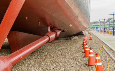 Closeup of large propeller on navel frigate in dry dock.