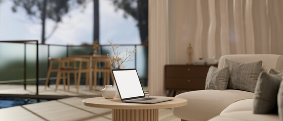 A laptop mockup on a minimal wooden coffee table in cozy contemporary living room