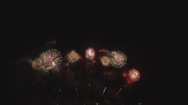 Real Fireworks on night backgrounds. abstract real shining fireworks with bokeh lights in the night sky. Celebration fireworks festival and New year's eve. Colorful fireworks. Footage b roll scenes.