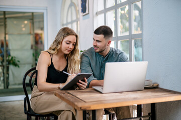 Happy young couple looking at laptop computer together at home. The concept of couples sharing one idea together.