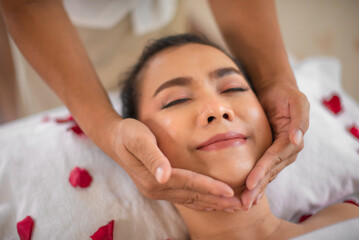 The skilled masseuse's gentle hands glided over the beautiful asian woman's chin with precision and expertise releasing tension and promoting a sense of deep relaxation.