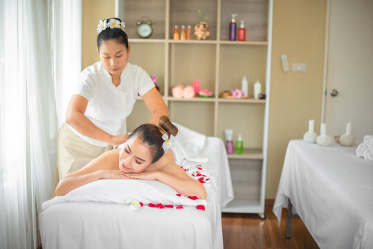 The skilled hands of the masseuse glided across the beautiful asian woman's body with precision and expertise creating a soothing and relaxing experience on the bed adorned with rose petals.