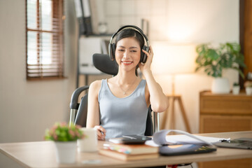 Naklejka premium Young Asian businesswoman reading graphs and talking on phone with customers in office