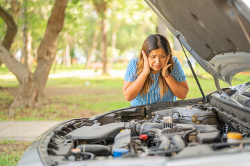 Fototapeta na wymiar woman shows helplessness at the sight of her car engine not running
