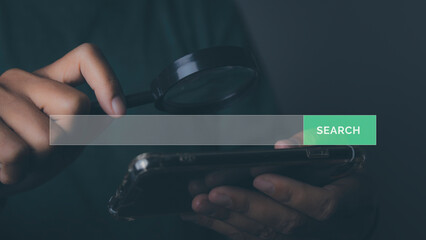 Businessman using magnifying glass search browsing for information by phone.