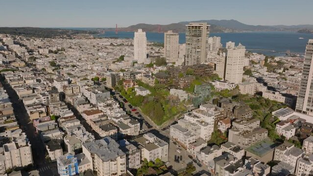 Aerial slide and pan footage of Russian Hill, Vallejo Street Crest District. Group of old houses on green hill surrounded by town development. San Francisco, California, USA