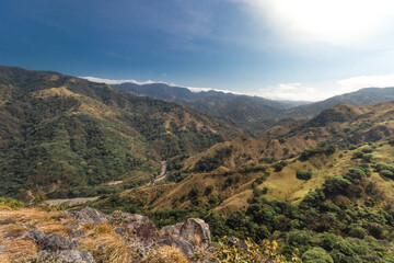beautiful landscape of green mountains full of nature and a riverbed on a hot sunny day in the province of Puntarenas in Costa Rica