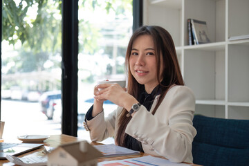 Fototapeta premium Portrait of smiling beautiful business asian woman working in office use computer. looking camera.