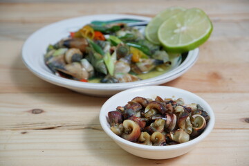 selective focus on white bowl serving sea snail or Laevistrombus canarium in Indonesian is called siput gonggong. soft focus