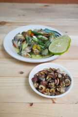 selective focus on white bowl serving sea snail or Laevistrombus canarium in Indonesian is called siput gonggong. soft focus