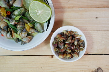 selective focus on white bowl serving sea snail or Laevistrombus canarium in Indonesian is called siput gonggong. soft focus