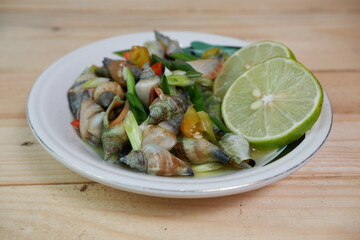 selective focus on white bowl serving sea snail or Laevistrombus canarium in Indonesian is called siput gonggong. soft focus