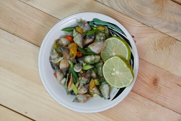 selective focus on white bowl serving sea snail or Laevistrombus canarium in Indonesian is called siput gonggong. soft focus